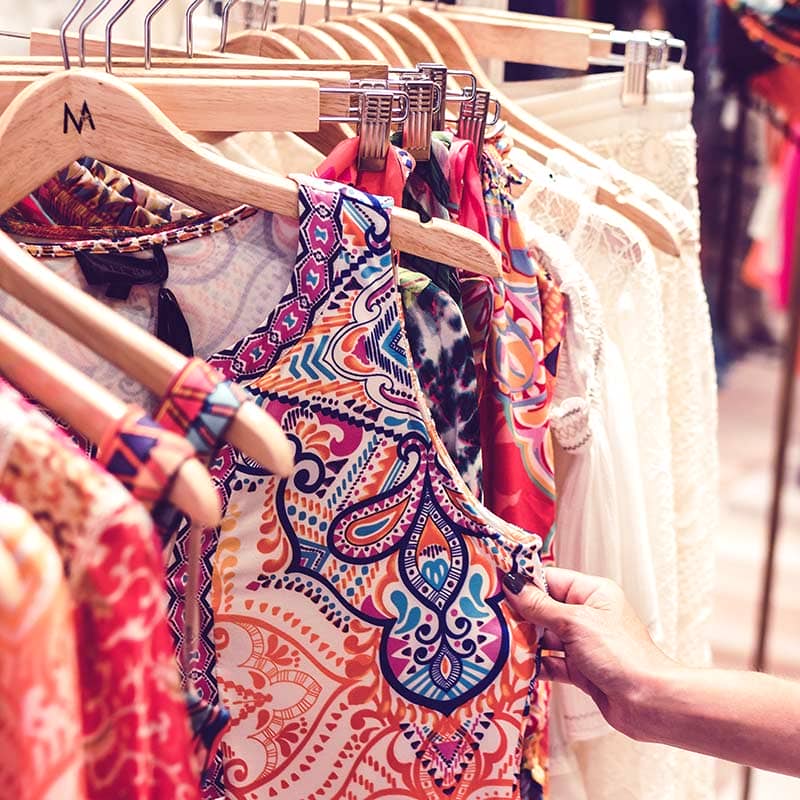 WD-easy-to-update A hand grabbing a colorful blouse off a clothes rack